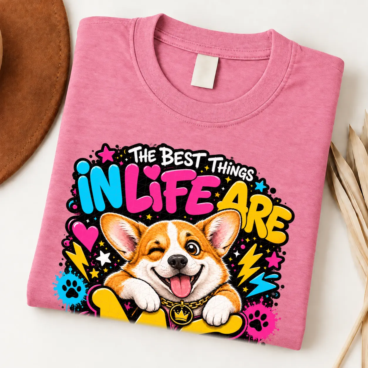 corgi pride shirt artwork with a winking orange-and-white corgi, tongue out, crown medallion, neon lettering, hearts, lightning bolts, and paw prints.