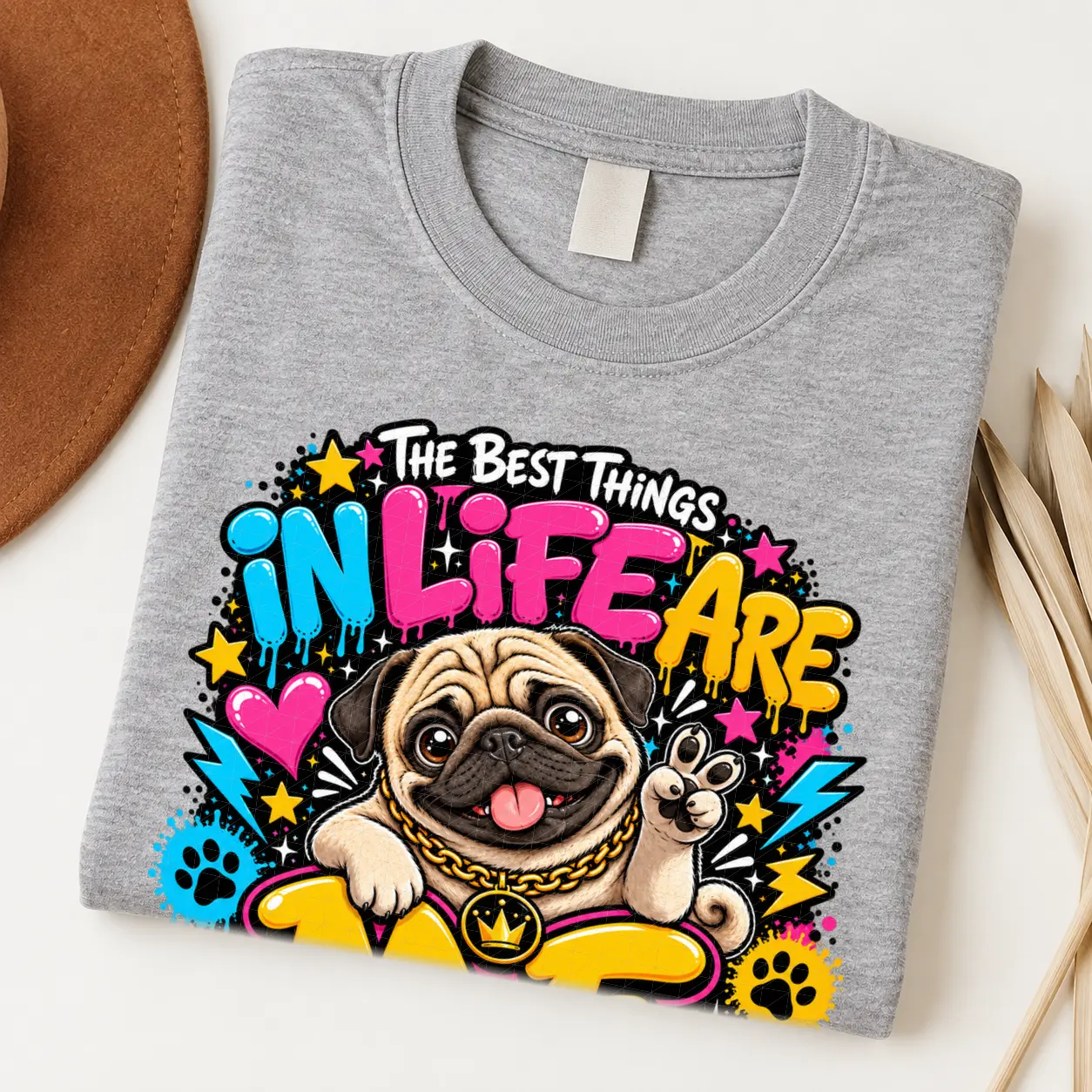 Pug pride shirt artwork with a smiling fawn pug, tongue out, peace-sign paw, crown medallion, neon lettering, hearts, paw prints, and lightning bolts.