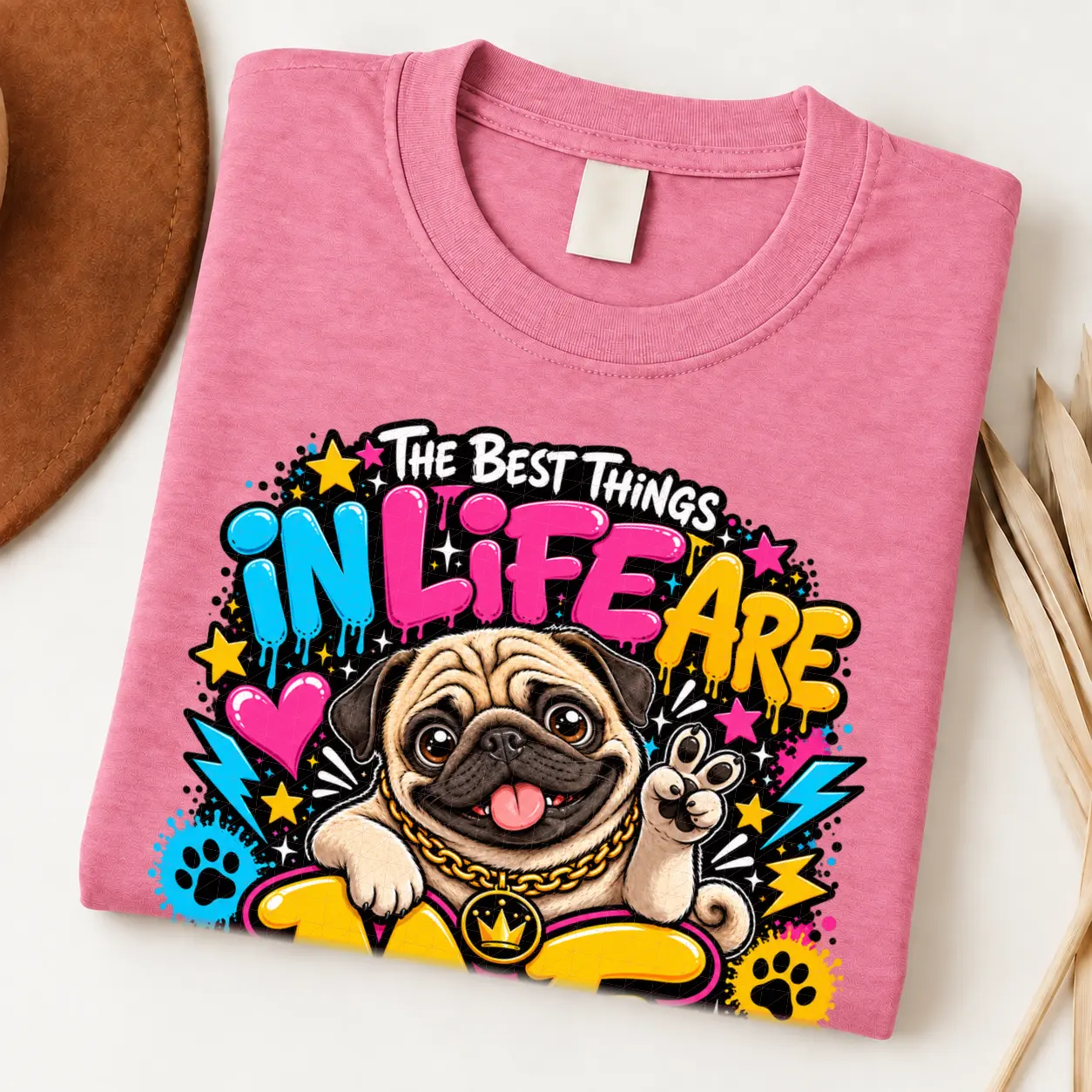 Pug pride shirt artwork with a smiling fawn pug, tongue out, peace-sign paw, crown medallion, neon lettering, hearts, paw prints, and lightning bolts.